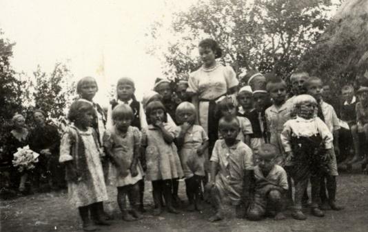 Wspólna fotografia dzieci i wychowawczyni na zakończenie pracy letniego dziecińca w Papierosówce (woj. wołyńskie).