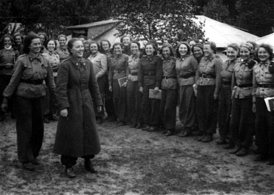 Uczestniczki obozu Przysposobienia Wojskowego Kobiet w Garczynie koło Kościerzyny (woj. pomorskie) żegnają  komendantkę (stoi w długim płaszczu), która wyjeżdża wcześniej, aby pożegnać się ze mężem powołanym do wojska w ramach powszechnej