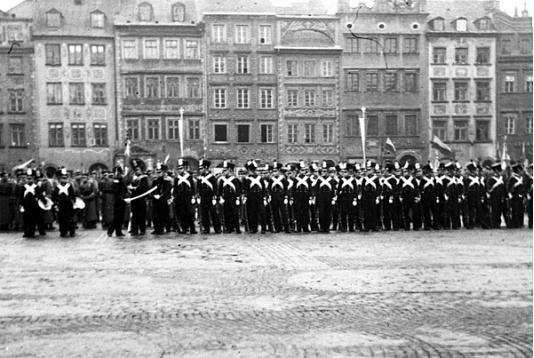 Dzień Podchorążego, uroczysta odprawa słuchaczy szkół wojskowych w strojach z czasów Powstania Listopadowego na Rynku Starego Miasta w Warszawie. W tle zabudowa strony Dekerta.